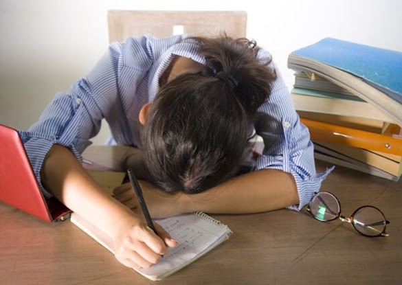 Female student with their head on their hands that has stopped studying